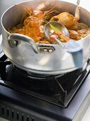 Crayfish stew in stew-pan on cooker