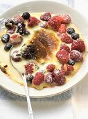 Crème brûlée with berries and icing sugar