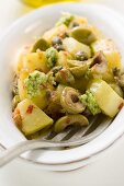 Spicy fried potatoes with olives, pesto and capers