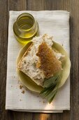 Pieces of white bread on plate with olive sprig, olive oil