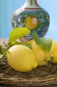 Frische Zitronen mit Blättern auf Korbtablett