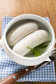 Two cooked Weisswurst in soup cup