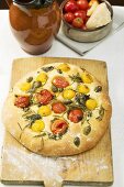 Pizza with cherry tomatoes, capers and rosemary