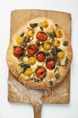 Pizza with cherry tomatoes, capers and rosemary