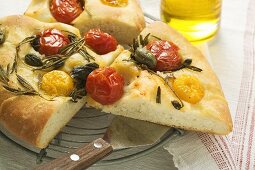 Three pieces of pizza with cherry tomatoes, capers & rosemary