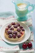 Cherry tart with icing sugar and custard