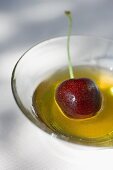 Honey with cherry in glass bowl