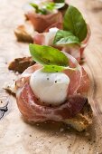 Crostini with Parma ham, mozzarella and basil