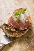 Crostini with Parma ham, mozzarella and basil