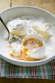 Flour, broken egg and butter in bowl