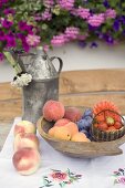 Sommerliches Obststillleben auf Tisch vor dem Haus