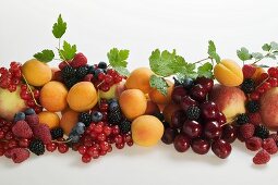 Fruit still life with stone-fruit, berries and leaves