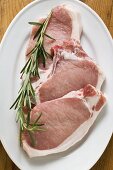Raw pork chops with rosemary