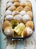 Buchteln (sweet yeast rolls) with icing sugar in baking tin