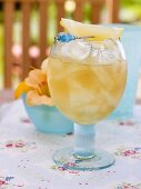 Fruity pineapple drink with ice cubes and lemon