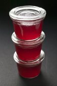 Three jars of redcurrant jelly in a pile