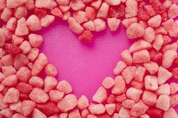 Small pink sweets, forming a heart shape