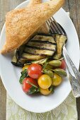 Grilled aubergines with cherry tomatoes, capers, flatbread