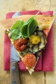 Stück Pizza mit Tomaten, Auberginen und Basilikum