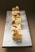 Small pieces of chocolate slice with macadamia nuts on board