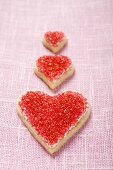 Three heart-shaped biscuits with red sugar