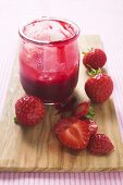 Jar of strawberry jam & fresh strawberries on chopping board