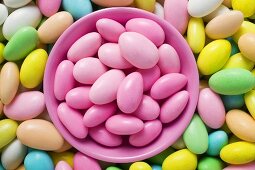 Sugared almonds, in and around pink bowl