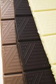 Pieces of three different chocolate bars (close-up)