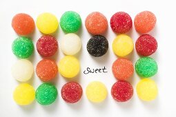 Many coloured jelly sweets in rows with the word 'Sweet'