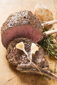 Rack of venison, partly carved, with garlic and rosemary