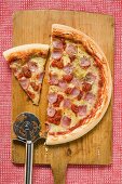 Ham pizza on chopping board (half and a slice)