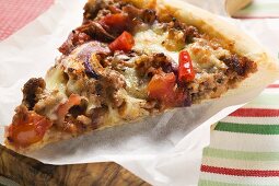 Slice of mince and onion pizza on paper