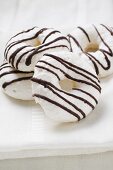 Meringue rings with chocolate stripes on white cloth