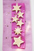 Star biscuits with sugar on purple paper (for Christmas)