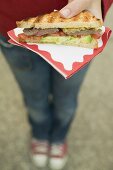 Person holding beef steak sandwich made with toast