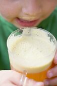 Child drinking a glass of freshly pressed apple juice