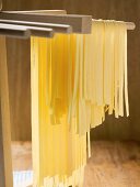 Home-made ribbon pasta hanging up to dry