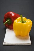 Two peppers (yellow, red) on white linen cloth
