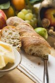 Still life with fruit, butter, nuts and baguette