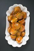 Currywurst (sausage with ketchup & curry powder) in paper dish (overhead)