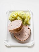 Leberkäse (type of meatloaf) with potato salad on paper plate