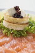 Soft cheese and caviar on toast on smoked salmon