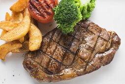 Grilled beef steak with vegetables and potato wedges