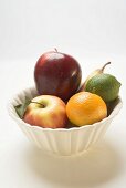 Core fruit and citrus fruit in white bowl