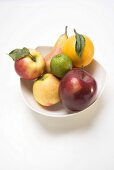 Core fruit and citrus fruit in white bowl