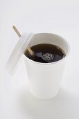Schwarzer Kaffee im Pappbecher mit Holzstäbchen