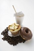 Muffin, doughnut, coffee beans and a plastic cup of coffee