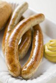 Sausages (bratwursts) with mustard on paper plate