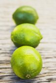 Three limes on wooden background