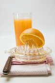Squeezing an orange, glass of orange juice